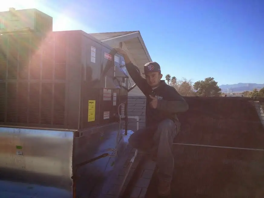 HVAC technician performing Boiler Repair on a rooftop unit in St. Martinville